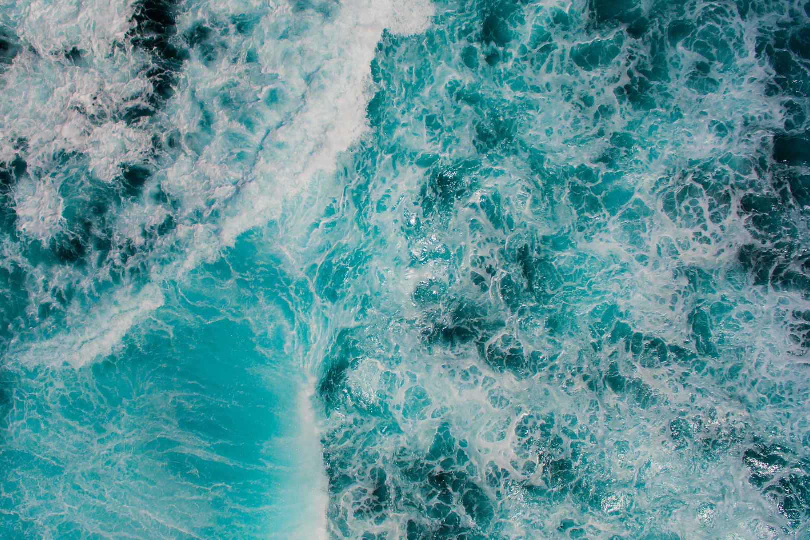 birds eye view of ocean waves crashing