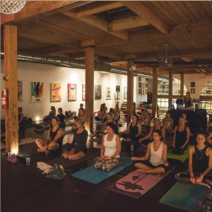 room full of people doing yoga TO112 sequence