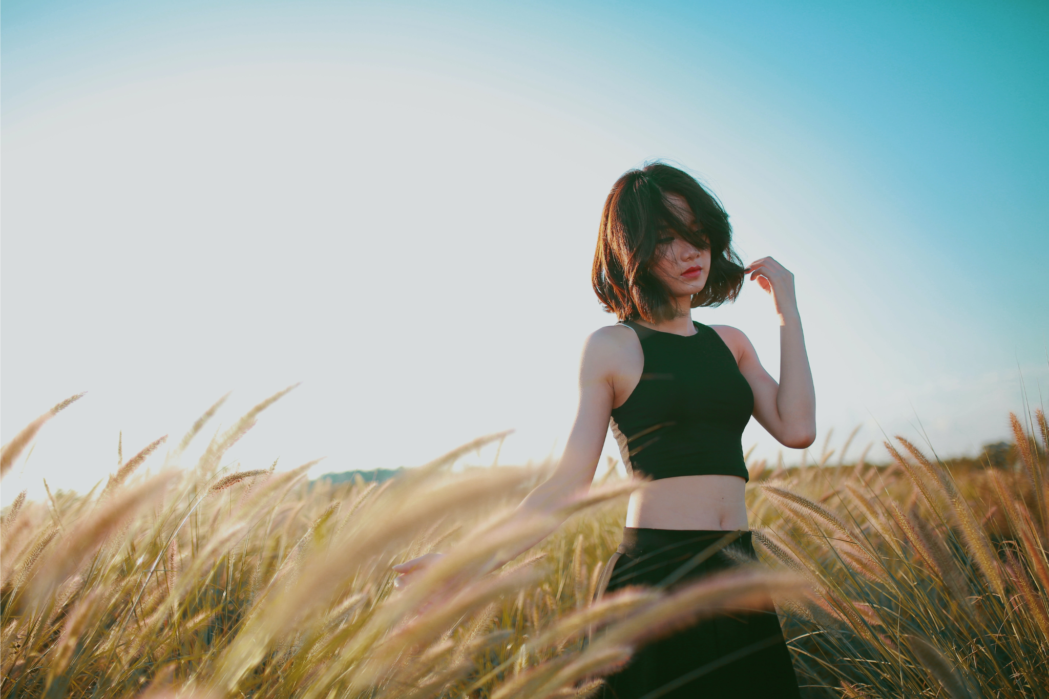 brunette woman in field of wheat straw