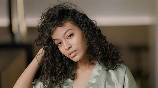 Model with shiny black curly hair after using TO112 products