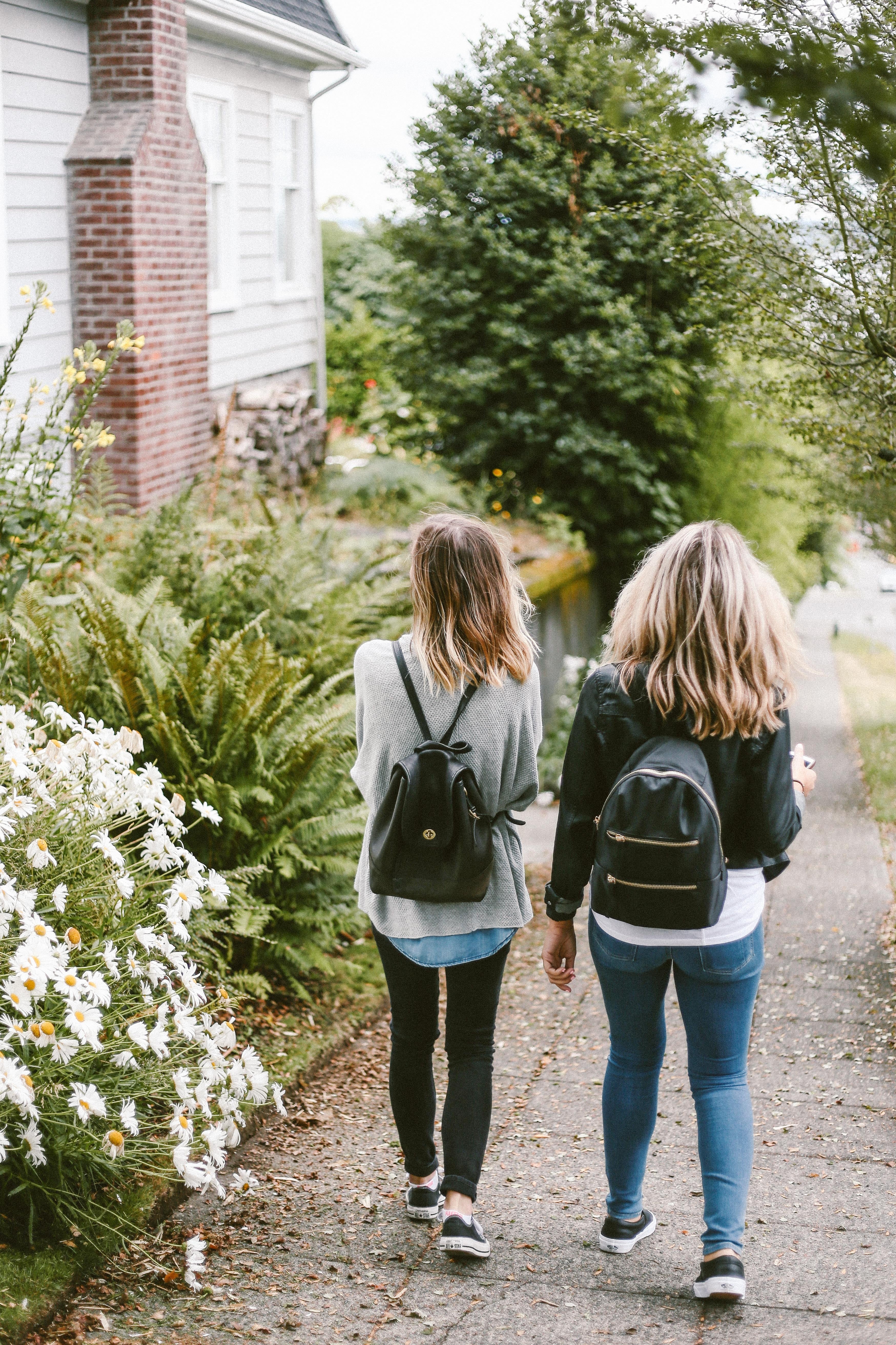 two people earing back packs walking on a summers day