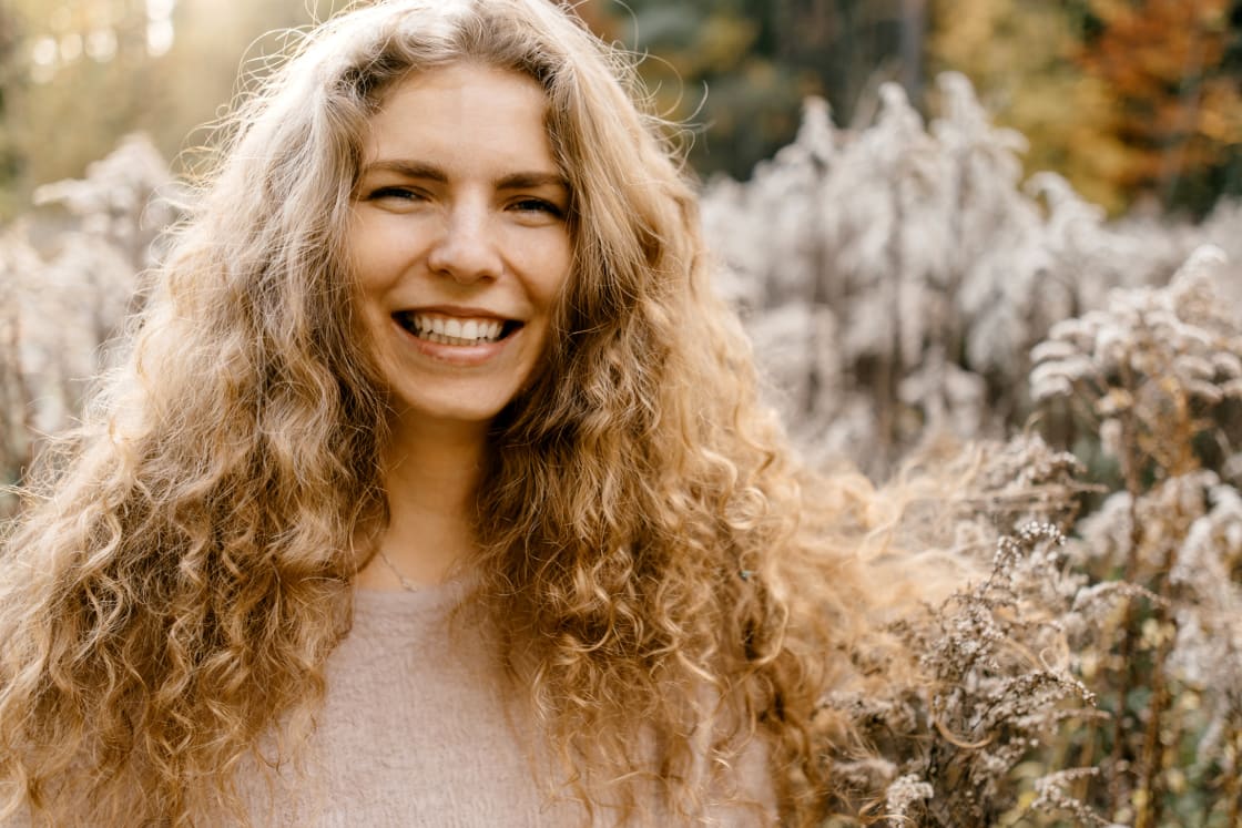 woman with frizzy blonde hair standing in field