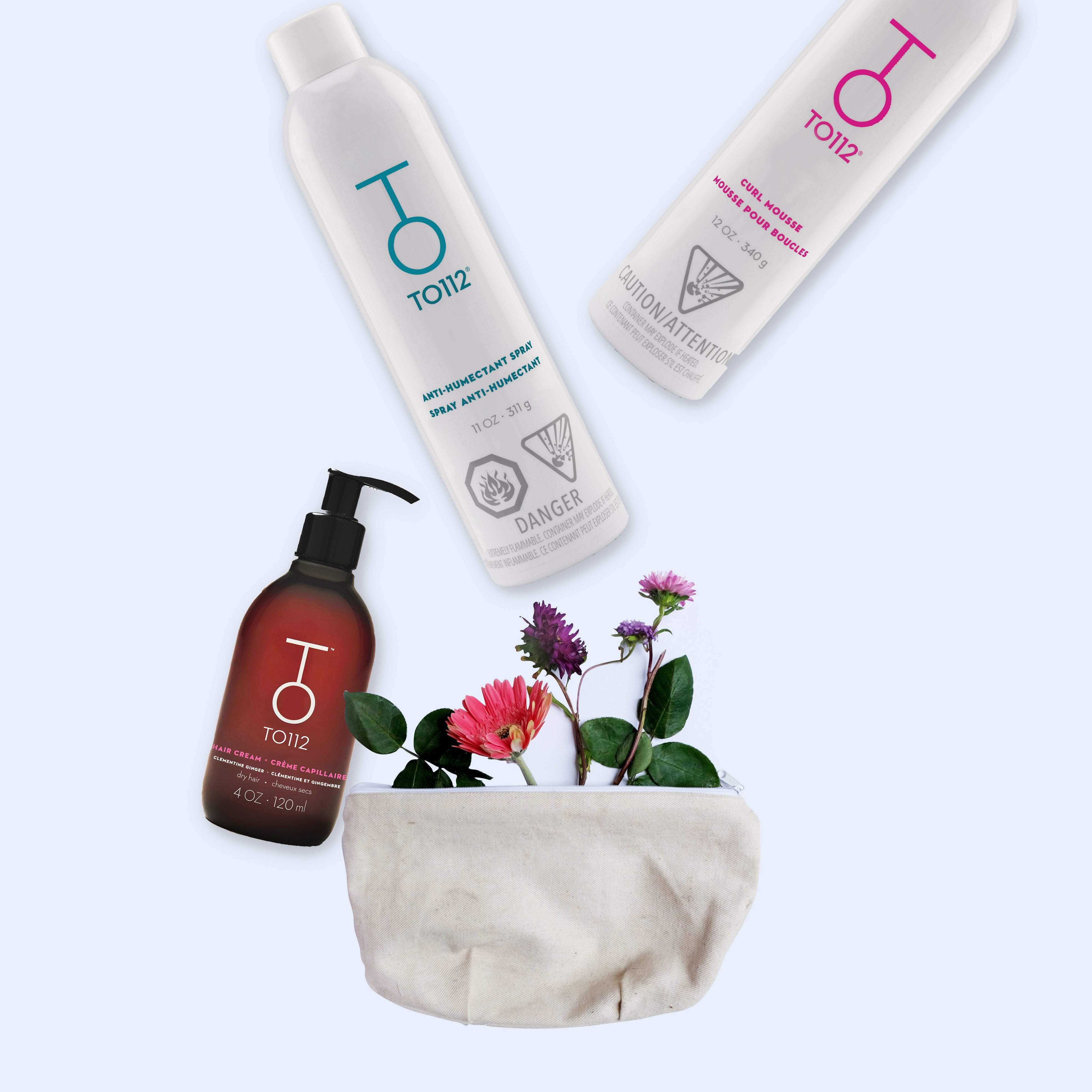 TO112 Ultimate Hair Cream TO112 Anti-Humectant Spray and TO112 Curl Mousse on white background with wild flowers