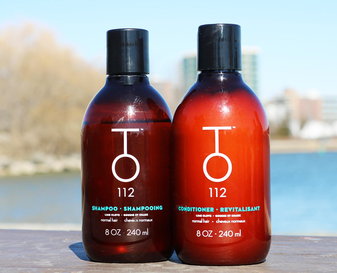 TO112 shampoo for balanced scalps and normal hair next to TO112 conditioner for normal hair in front of lake and city landscape