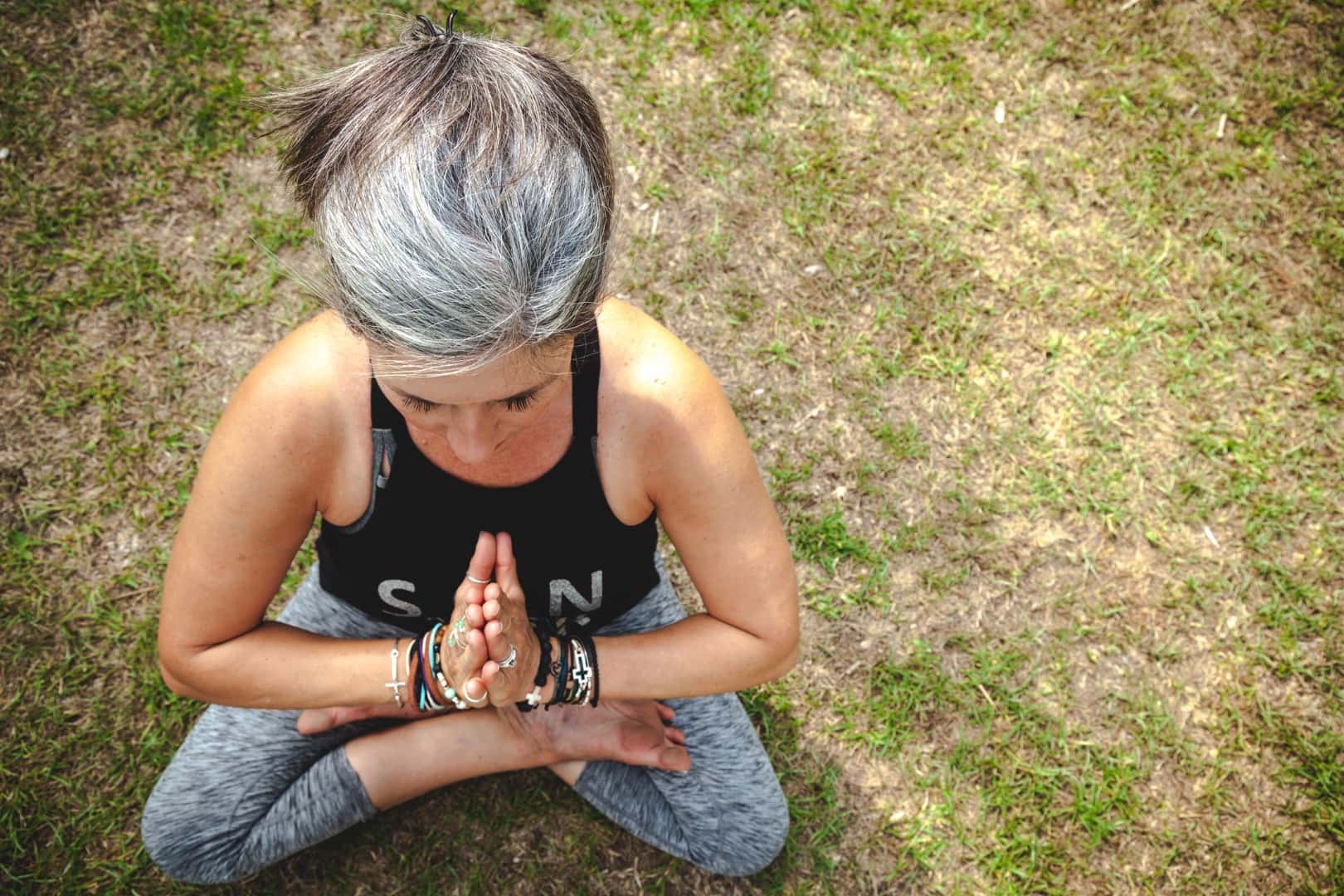 gray haired woman doing yoga birds eye view
